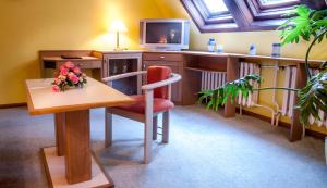 奥古斯都堡奥古斯塔酒店的一间配备有桌子、电视和椅子的客房