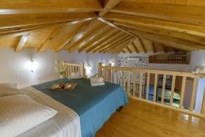 伊兹拉Guarda il porto的一间带一张床的卧室,位于带木制天花板的房间内