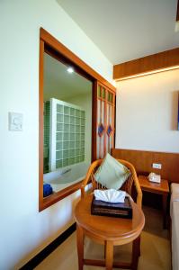 蔻立Khaolak Orchid Beach Resort - SHA Extra Plus的客房设有一张床和一张带镜子的桌子