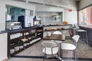 巴塞罗那新图昂弗酒店的厨房配有白色的椅子、桌子和柜台