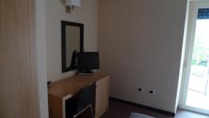 Capistrello德梅斯酒店的客房设有一张带电视和镜子的书桌