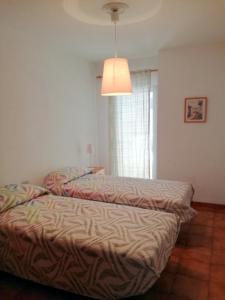 厄尔梅达诺El Medano - Cerca de la Playa的两张床铺位于带灯的房间