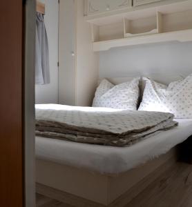 德布吉Domki holenderskie ,, Latający Holender"的一间卧室配有带白色床单和枕头的床。