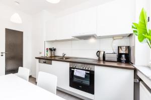 科隆科隆公寓的厨房配有白色橱柜和炉灶烤箱。