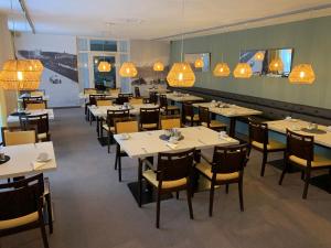 丁戈尔芬Hotel Garni Max Zwo的用餐室配有桌椅和吊灯。