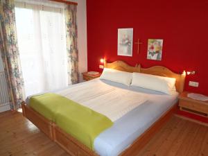 萨菲登安斯泰内嫩米尔澳贝尔斯托金霍夫酒店的一间卧室设有一张红色墙壁的大床