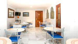 格拉纳达阿尔贝罗酒店的一间配备有桌子和蓝色椅子的用餐室
