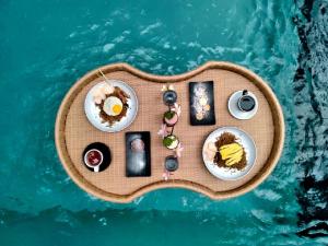 坎古Annupuri Villas Bali的水面上带食物的小型桌子