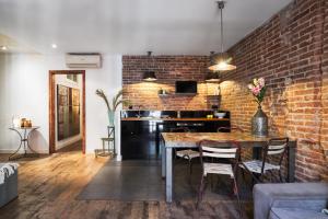 巴塞罗那Brummell Apartments Eixample Izquierda/Valeris的厨房设有砖墙和桌椅