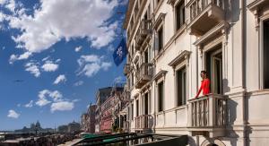 威尼斯Londra Palace Venezia的站在建筑物阳台上的妇女