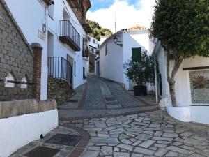 BenalauríaCasa Rural Pimentel的村里一条鹅卵石街道,有白色的建筑