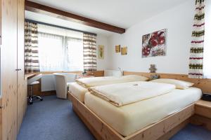 欣特察尔滕斯尔博迪斯特尔酒店的一间卧室设有两张床、一张桌子和一个窗口。
