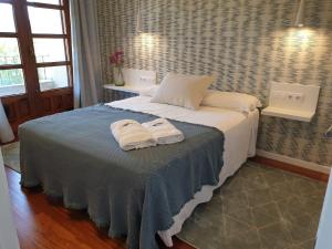 阿尔丹Apartamentos Ria de Aldan的一间卧室配有一张床,上面有两条毛巾