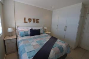 乌姆德洛蒂Cozumel 410的卧室配有一张挂有爱情标志的床