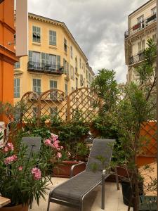 尼斯勒潘特酒店的庭院设有长凳、鲜花和建筑