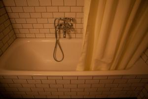 雷克雅未克客可思旅舍的浴室设有带淋浴喷头的浴缸。
