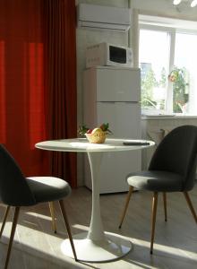 罗夫诺Rusalika的厨房里配有一张白色的桌子和两把椅子
