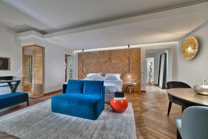 蒙特格罗托泰梅Esplanade Tergesteo - Luxury Retreat的一间卧室配有一张床、一张蓝色的椅子和一张桌子