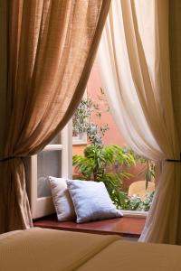 埃尔莫波利斯Xenon Apollonos的窗户前有窗帘和枕头