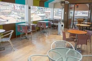 库斯科库斯科行囊旅舍的餐厅设有桌椅和窗户。