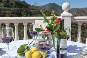 赛阿隆加Fuentezuelas Pool Villa的一张桌子,配有酒杯和一瓶葡萄酒