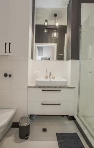 比亚韦斯托克CR Apartament w Śródmieściu Sienkiewicza 1的白色的浴室设有水槽和淋浴。