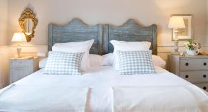 坎德莱达拉卡萨德罗斯特米拉瑞斯酒店的卧室配有白色床和蓝色及白色枕头