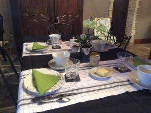 La CambeFerme de Savigny的一张桌子,上面有黑色和白色的桌布,上面有绿色的餐巾