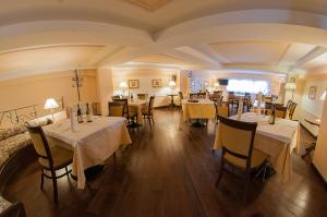 佩斯卡塞罗利Hotel Garnì Posta的一间在房间内配有桌椅的餐厅
