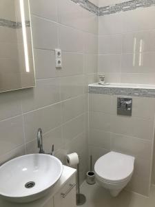 松博特海伊Bervia Apartman的白色的浴室设有水槽和卫生间。