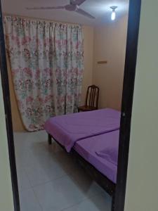 拉瑙Homestay pekan ranau的一间卧室设有紫色的床和窗户