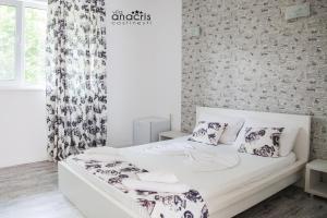 科斯蒂内什蒂Anacris Guesthouse的卧室配有带枕头的白色床