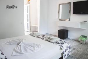 科斯蒂内什蒂Anacris Guesthouse的一张白色的床,位于带镜子的房间里