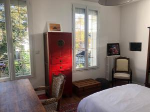 马恩河畔维列Maison du bonheur的卧室配有红色梳妆台,位于床边