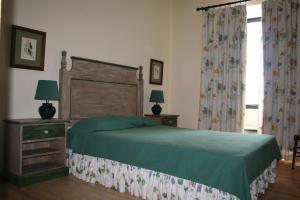 马尔旺阿瓦利酒店的一间卧室设有一张绿色的床和一个窗户。