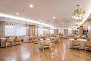 上海上海青松城大酒店的用餐室配有白色桌椅和吊灯。