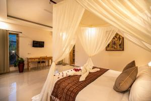 乌布Puri Sedana Ubud Villa的一间卧室配有一张带天蓬的床