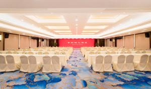 上海上海青松城大酒店的空的宴会厅,配有白色的桌椅