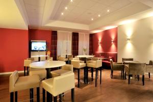 巴尔莱本萨克森 - 安哈特酒店酒店的餐厅设有桌椅和平面电视。