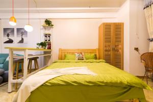 西宁【路客】西宁市城西区·万达广场·路客精品公寓·00151730的一间卧室配有一张绿色的床和一张桌子