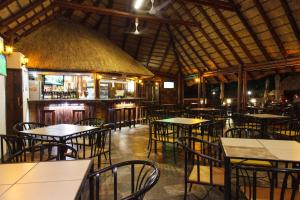 侯斯普瑞特Swadini, A Forever Resort的一间带桌椅的餐厅和一间酒吧