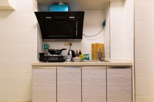西宁【路客】西宁市城西区·万达广场·路客精品公寓·00151730的厨房配有带微波炉的台面