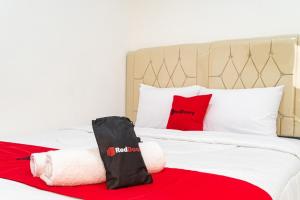 雅加达RedDoorz near Tarumanagara University的一间卧室配有红色枕头的床