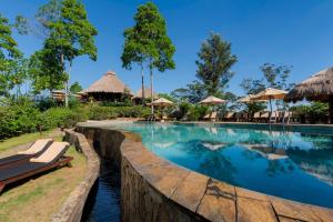 埃拉98英亩Spa酒店的度假村的游泳池,配有椅子和遮阳伞