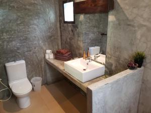 通萨拉班蒙拉里度假酒店的一间带水槽、卫生间和镜子的浴室