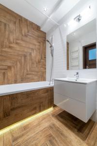 比得哥什Apartament Jaskółcza 30的一间带白色水槽和木墙的浴室