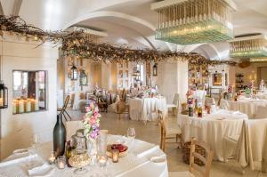萨维勒特里博尔戈艾格纳齐亚酒店的用餐室配有白色桌椅和吊灯。