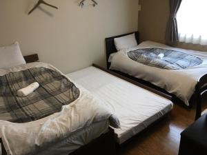 广岛玛丽卡旅舍的带窗户的客房内设有两张单人床。