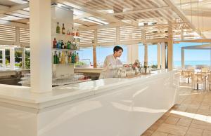 梵蒂冈角Capovaticano Resort Thalasso Spa的站在餐厅酒吧的厨师