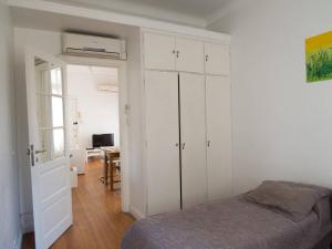 布宜诺斯艾利斯Silencioso departamento antiguo的卧室配有白色橱柜、一张床和一张桌子。
